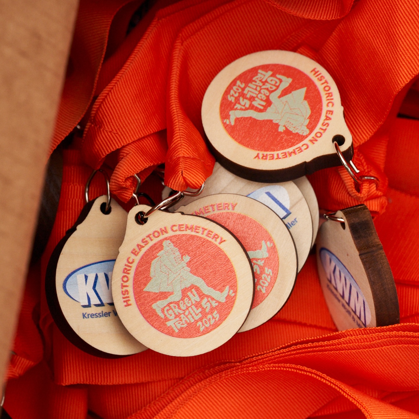 green traill medals - logo and sponsor printed on a wooden cicle