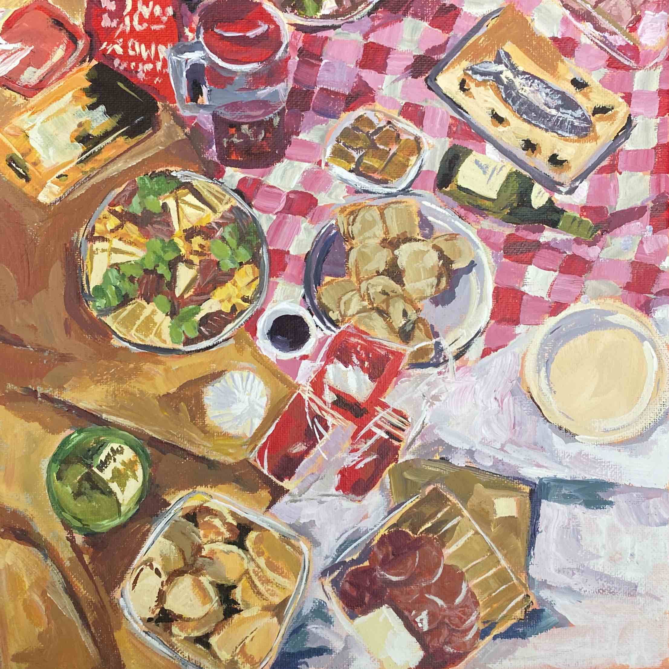 a picnic scene showing a collection of different foods on a blanket